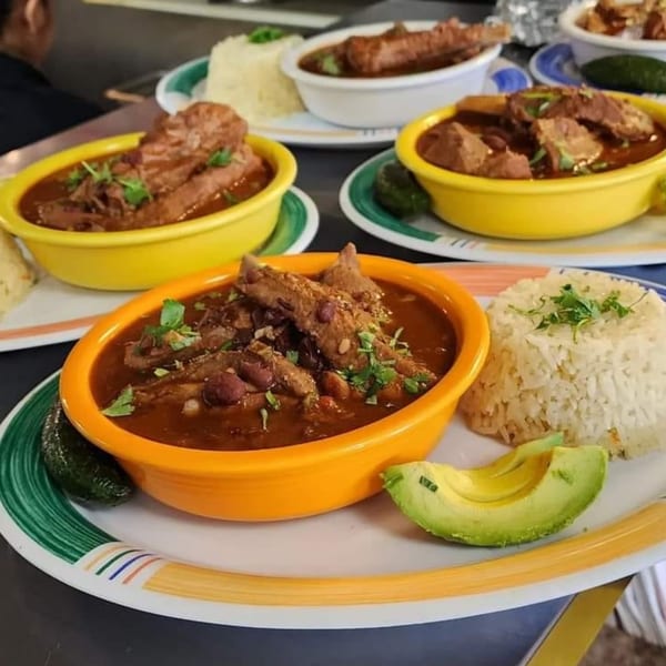 Multiple bowls of Jacky's Restaurant's Mexican stew with rice, avocado, and pickled jalapeños.